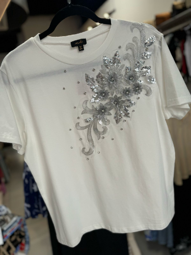 Blusa blanca detalle de flores plateadas